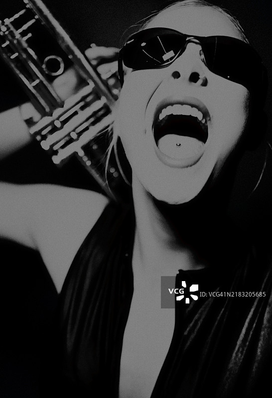 手持小号的年轻女性。图片素材