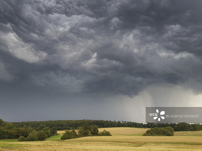 一场带有大雨和冰雹的雷暴云团经过德国黑森州韦特劳地区的布茨巴赫。图片素材