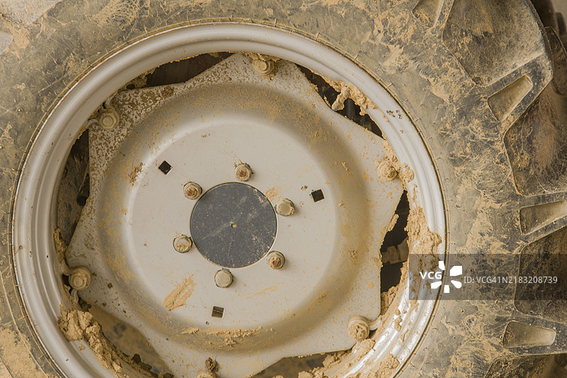 阳光明媚的韩国，泥泞的拖拉机轮胎和车轮特写图片素材