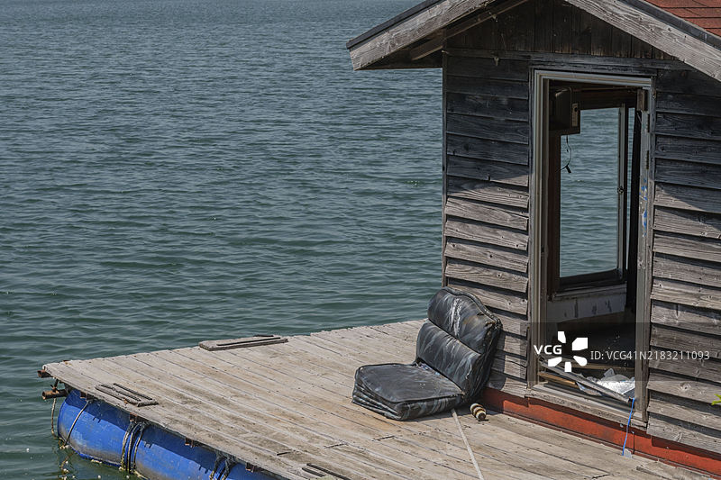 废弃的老渔舍和漂浮在湖面上的码头图片素材