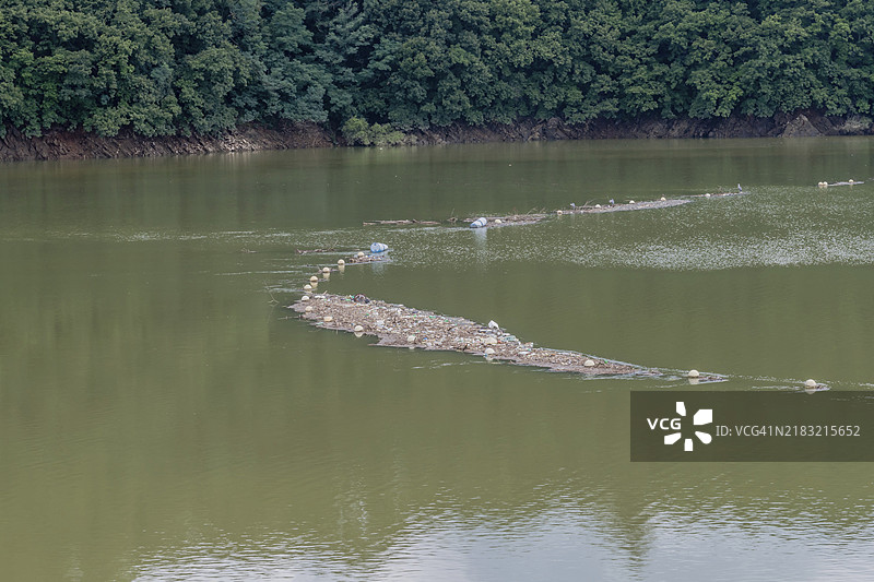 在韩国大田的水库中，网正在收集垃圾和杂物的垃圾岛图片素材