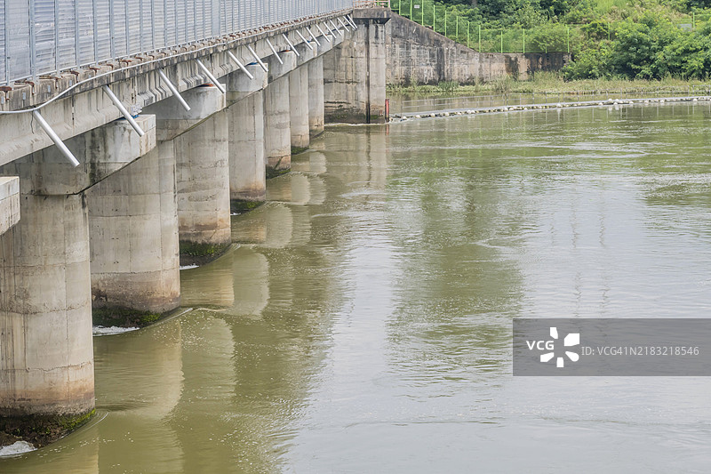 一座坚固的混凝土桥横跨宽阔的河流，倒映在水面上，位于韩国。图片素材