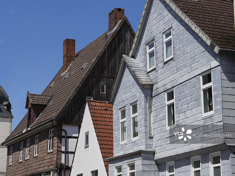 一排具有独特红色屋顶的半木结构房屋,蓝天之下,德国北莱茵-威斯特法伦州德特莫尔德,欧洲图片素材