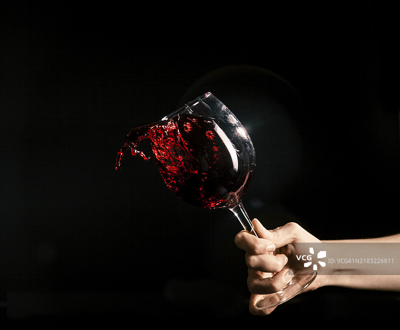 手部从酒杯中溅出酒液图片素材
