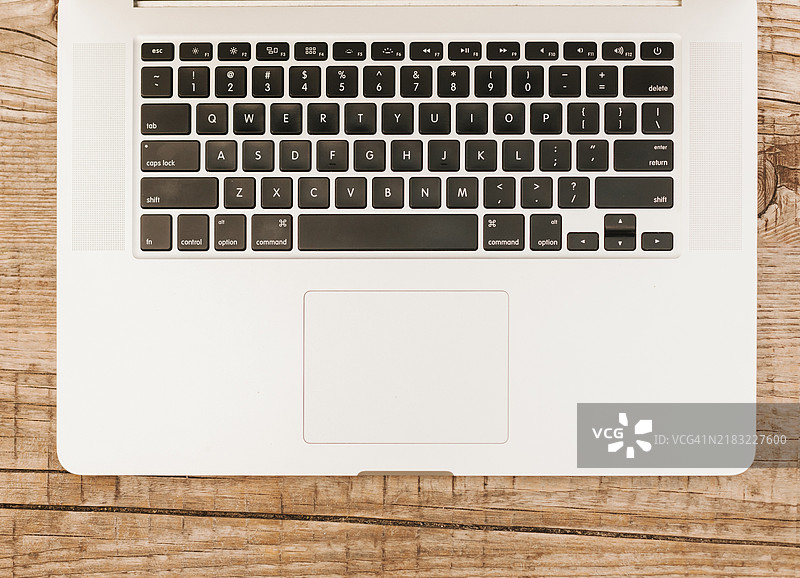 顶视图笔记本电脑键盘与木质背景图片素材