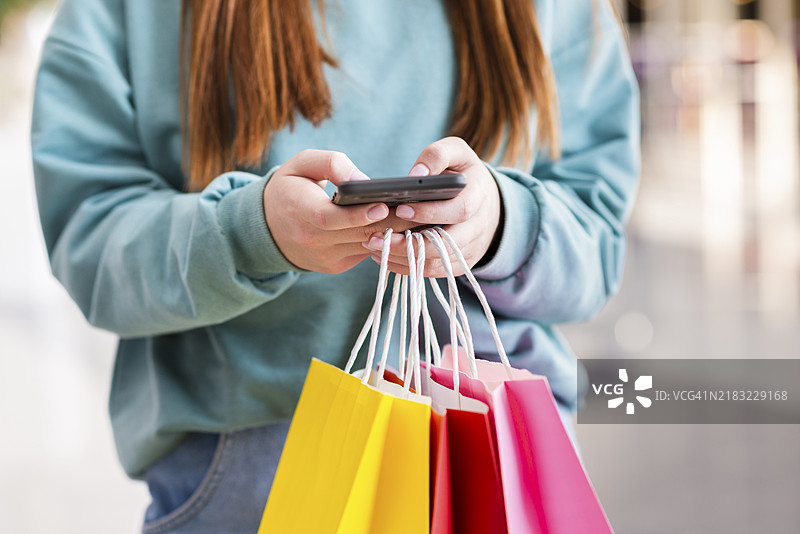 手握纸袋和手机图片素材