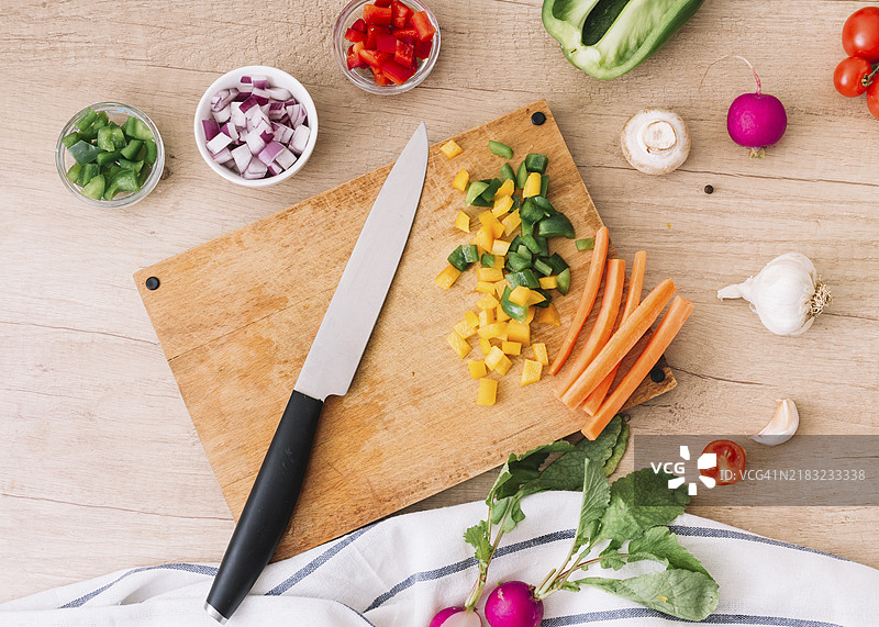 俯视切菜板、刀具和蔬菜的木桌图片素材