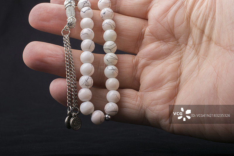 一手握着各种颜色的念珠。图片素材