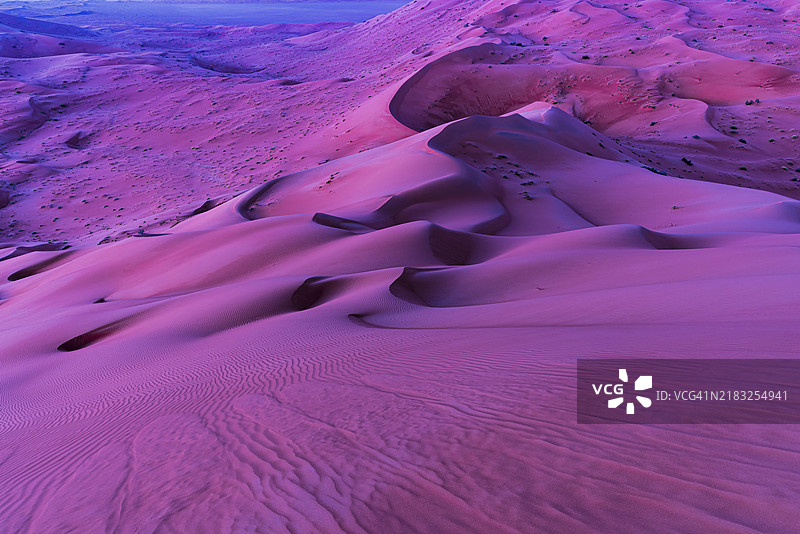 在阿曼苏丹国的鲁卜哈利沙漠，德霍法省，日出前的风雕刻的弯曲沙丘图片素材