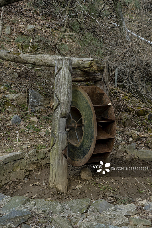 山坡公共公园中的旧锈蚀金属水车图片素材