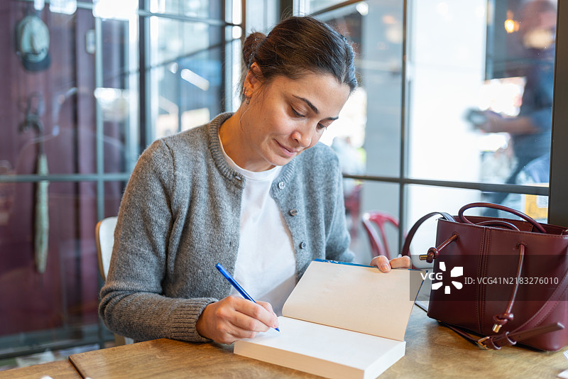 女人在餐厅里写日记图片素材