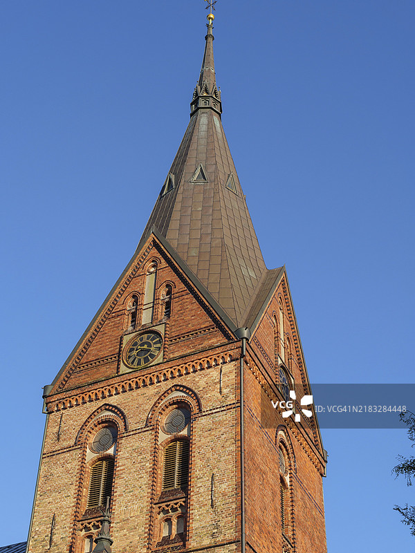 一座历史悠久的砖砌教堂塔楼在晴朗的蓝天下特写，弗伦斯堡，石勒苏益格-荷尔斯泰因，德国，欧洲图片素材