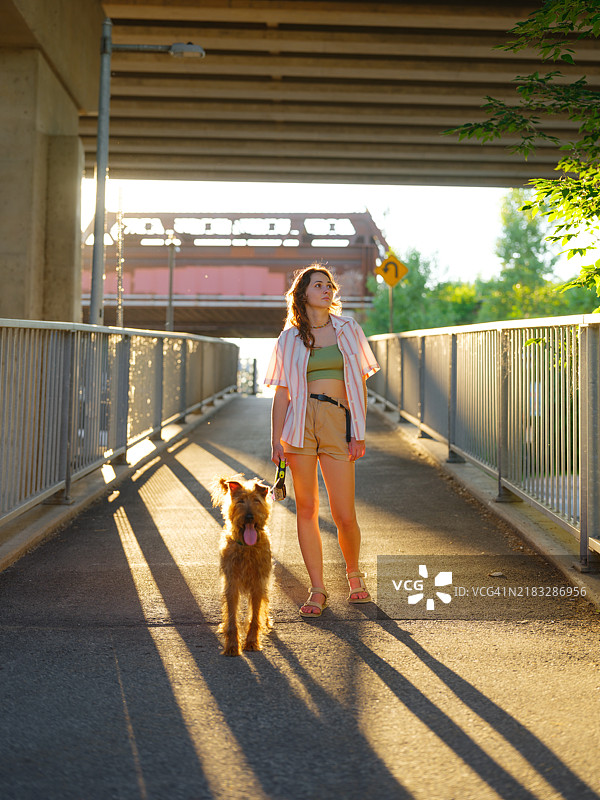 加拿大郊区一位女性牵着狗散步图片素材