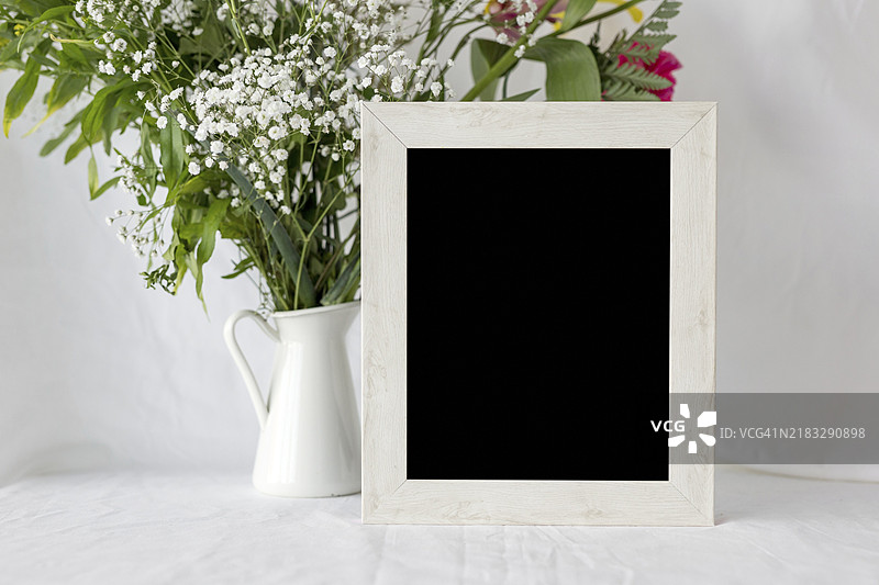 空白框架与白色桌子上的花瓶图片素材