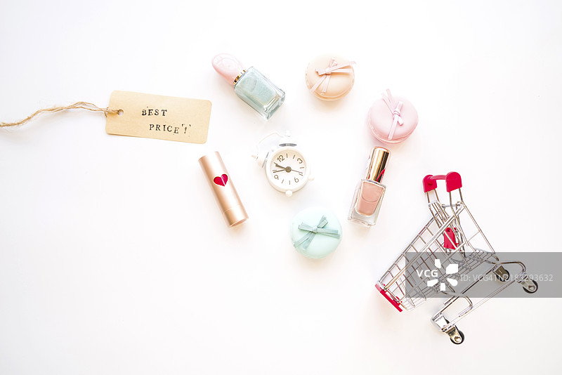 购物车里有小闹钟、马卡龙、售价标签、口红和指甲油图片素材