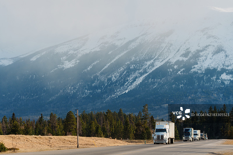 春季穿越加拿大落基山脉的高速公路上的卡车图片素材