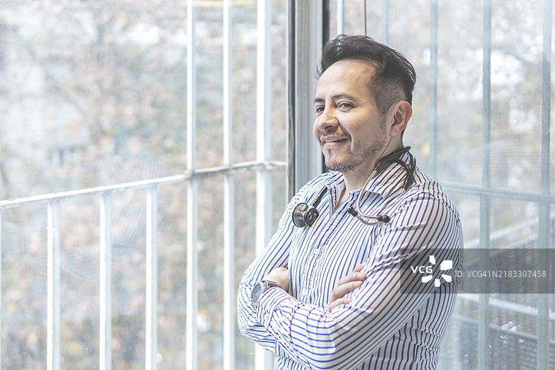 拉丁裔医生在办公室摆姿势的肖像图片素材