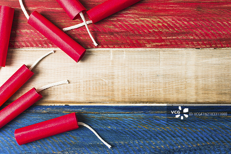 红色炸药鞭炮与木制涂漆木板背景图片素材