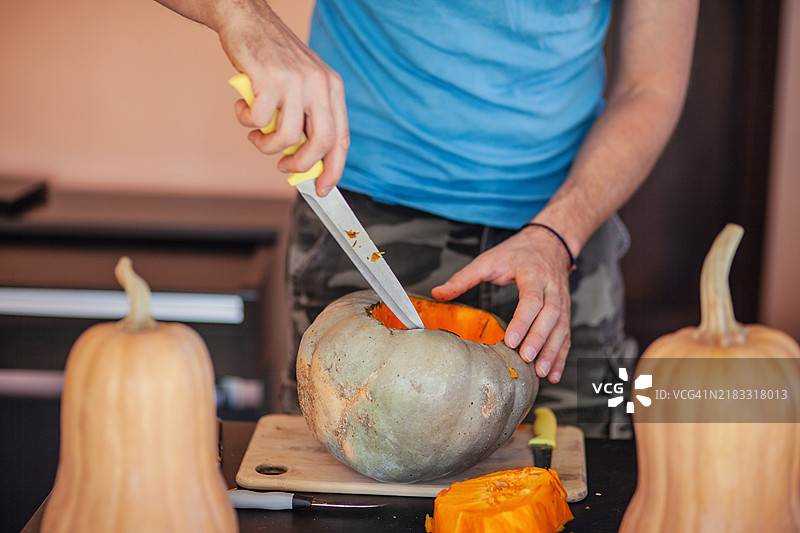 男子在桌子上雕刻南瓜的中部，保加利亚图片素材