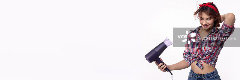 时尚自信的女性手持吹风机，展现出她明亮的时尚感图片素材