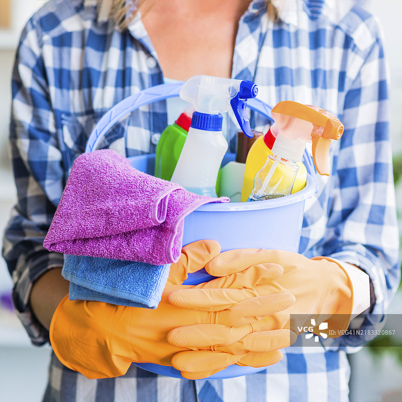 中年女性手持清洁工具和蓝色水桶图片素材