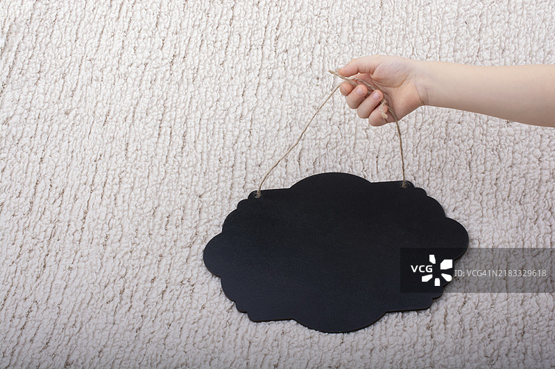 白色背景上手持黑色气泡形状的公告板图片素材