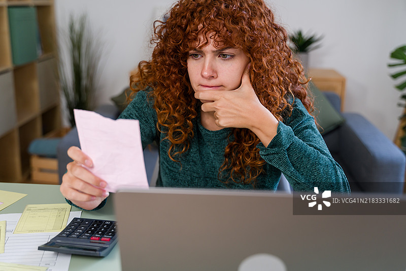 压力大的会计在家中办公室阅读账单并计算开支图片素材