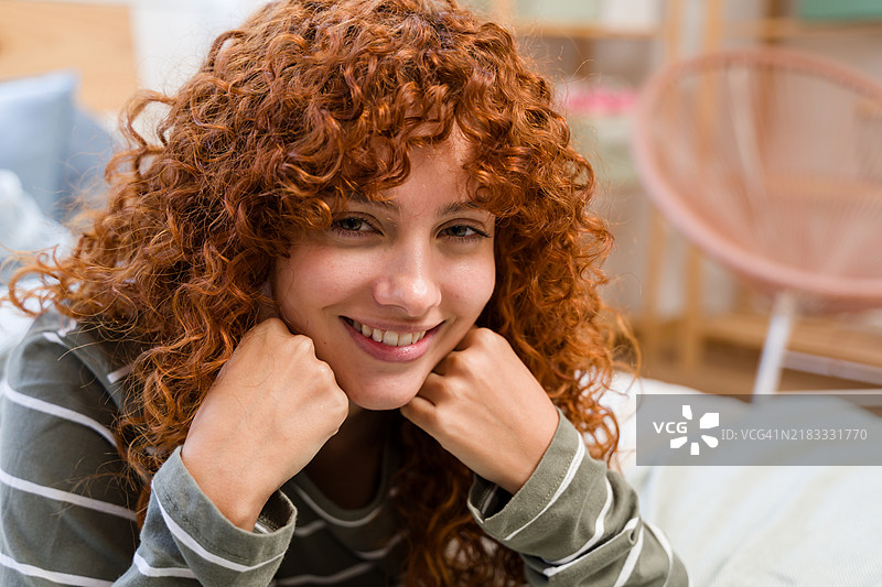 美丽的红发女性在家微笑并放松图片素材