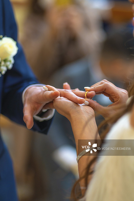 新娘即将为新郎戴上戒指，场景优美的婚礼仪式图片素材