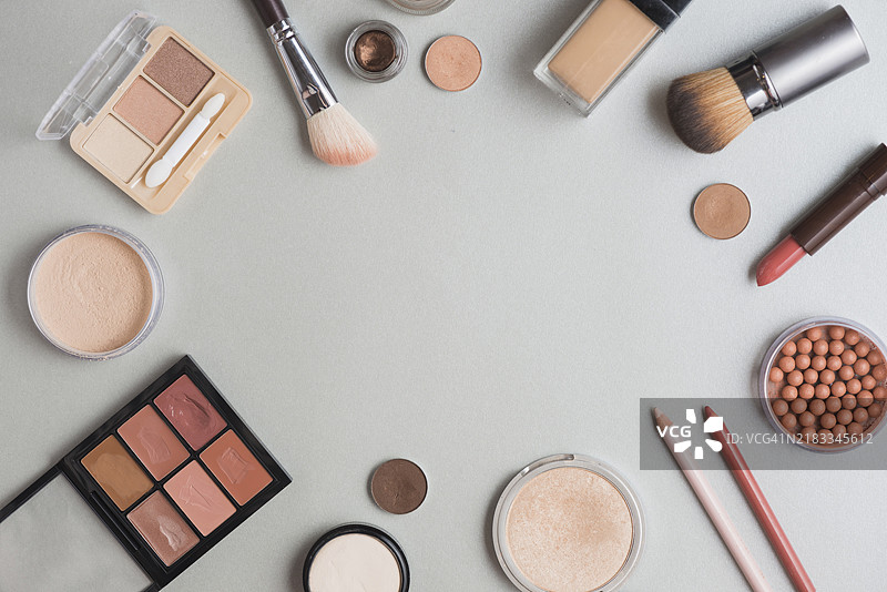 高角度视图的化妆套件呈圆形排列，背景为白色图片素材