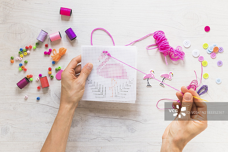 特写人物进行十字绣刺绣，使用绣线和装饰元素图片素材