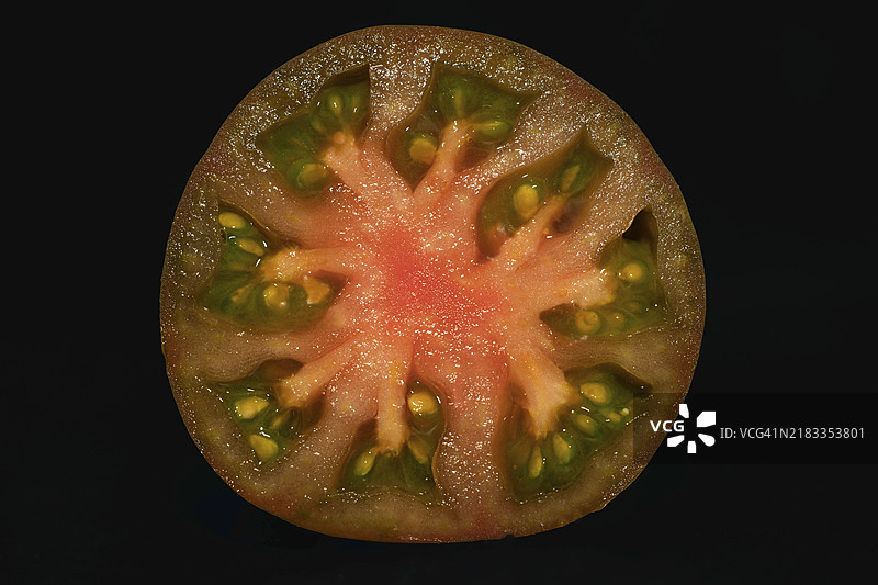 黑克里米亚品种的切片番茄（Solanum lycopersicum）特写，食品摄影，黑色背景图片素材