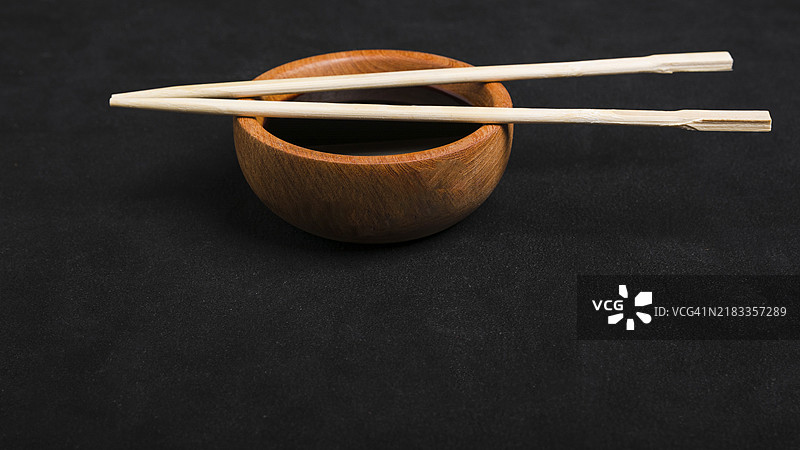筷子、酱油、木碗，黑色背景图片素材