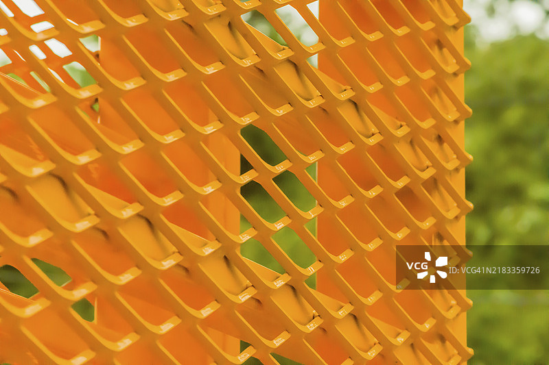 模糊背景下的黄色金属结构特写，带有V形图案图片素材