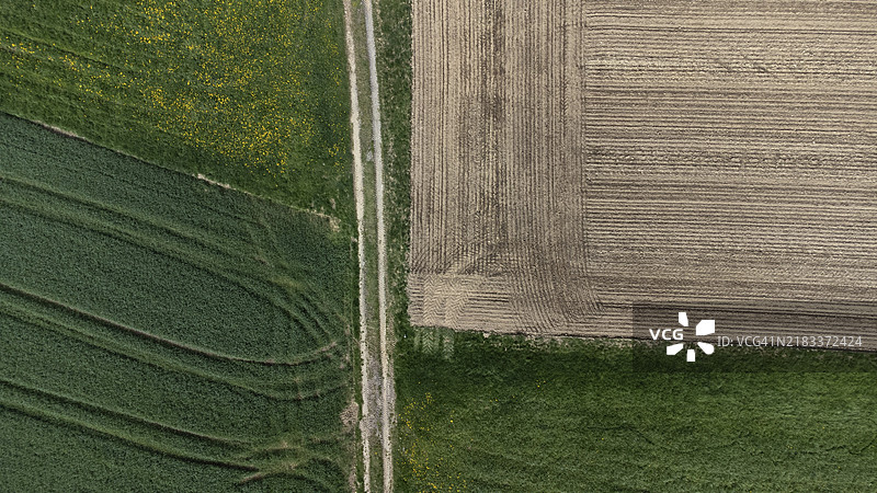 一条土路将不同的农业区域分开，从鸟瞰图看有趣的图案，航拍图，巴伐利亚下部，德国，欧洲图片素材