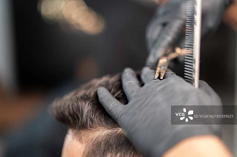 理发师为顾客修剪头发长度图片素材