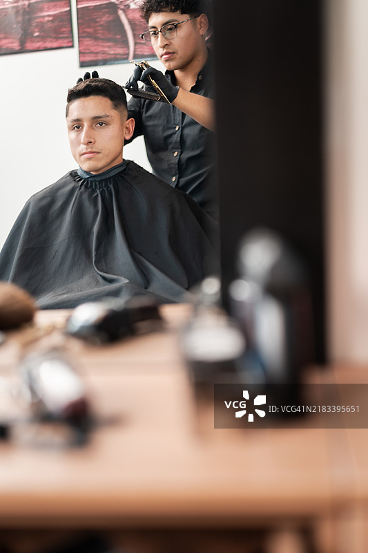 男子在理发店理发时照镜子图片素材