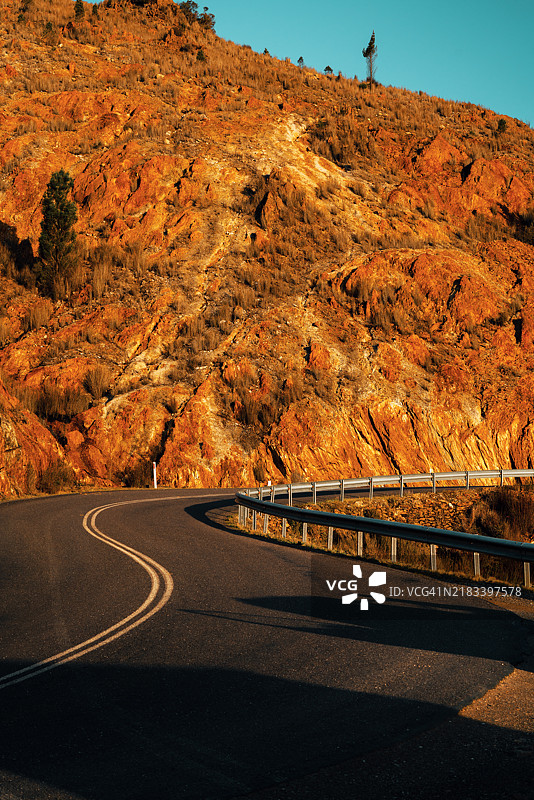 蜿蜒的道路穿过塔斯马尼亚澳大利亚的昆士镇山脉，岩石表面如同月球表面。图片素材