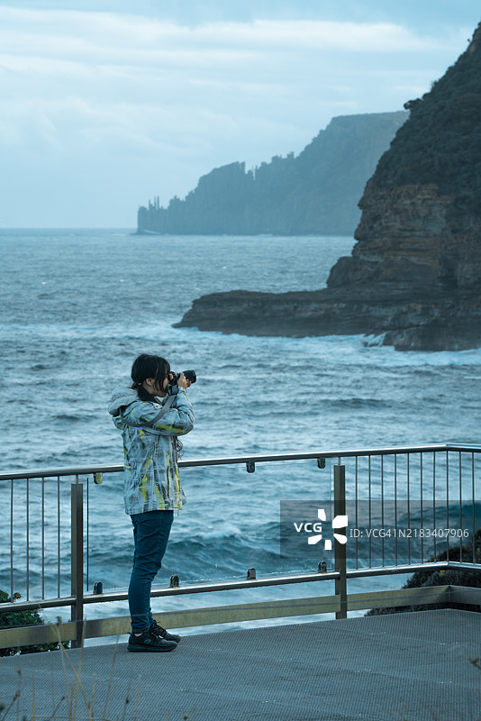 一位女性游客正在用数码相机拍照图片素材