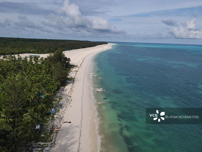 宽广的热带海滩，船只和棕榈树成排而立图片素材