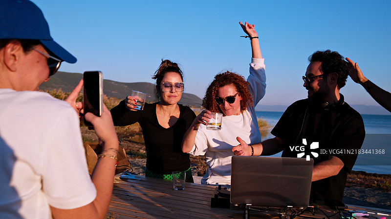 朋友们在私人海滩聚会、饮酒和享受乐趣图片素材