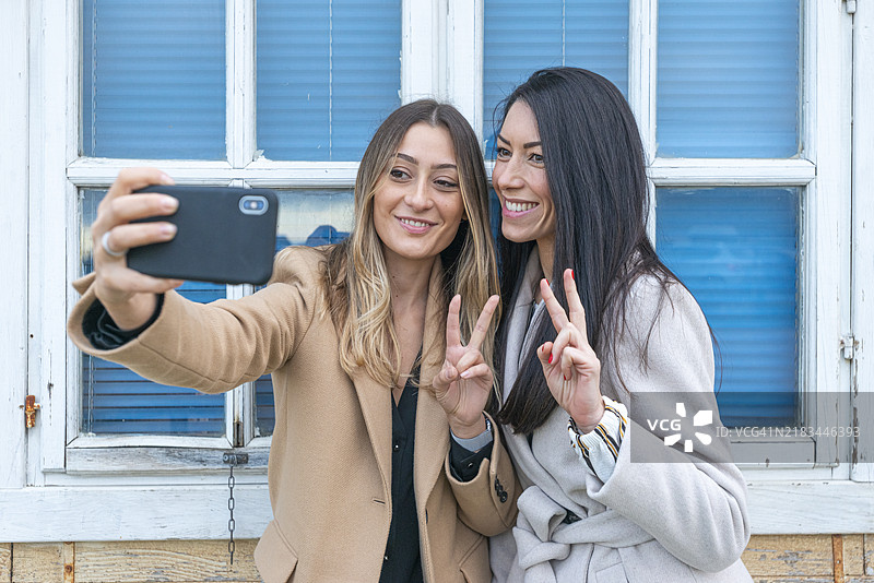 两个朋友自拍并做出胜利手势图片素材