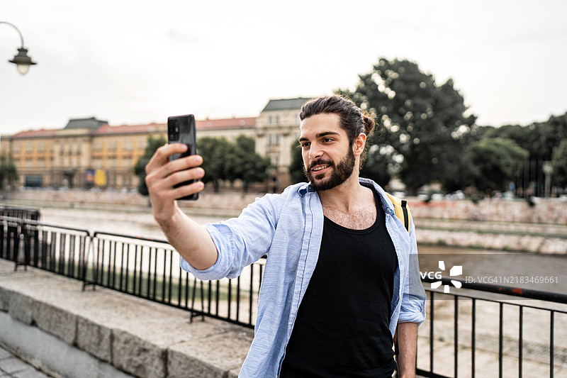 年轻男子在城市中用相机录制视频图片素材