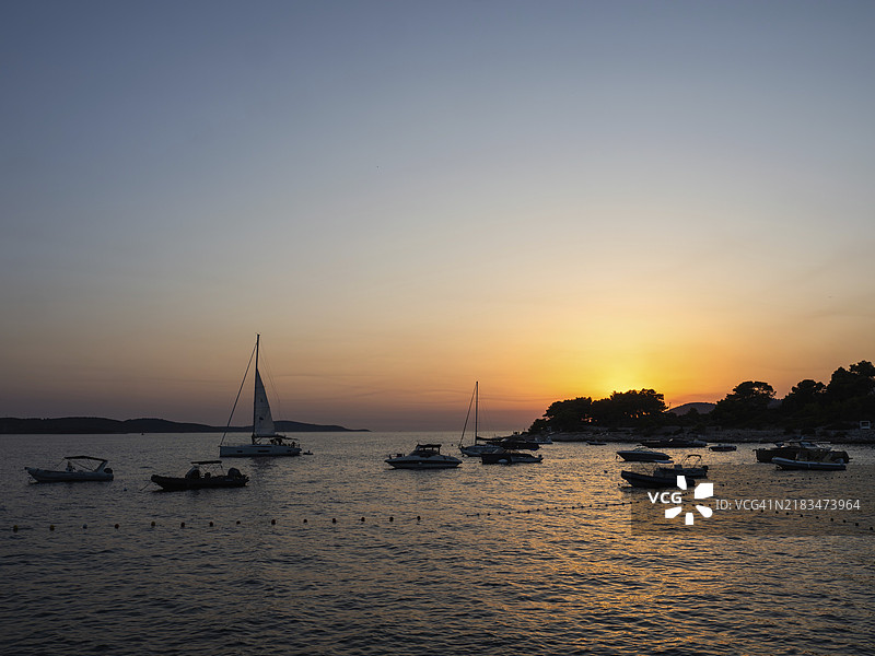 日落，港口中的船只，赫瓦尔镇，赫瓦尔岛，达尔马提亚，克罗地亚，欧洲图片素材