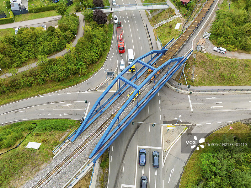 德国黑森林卡尔夫的赫尔曼·黑塞铁路，蓝色桥梁脚手架的公路与铁路交叉口的鸟瞰图，轨道施工，铁路运输。图片素材