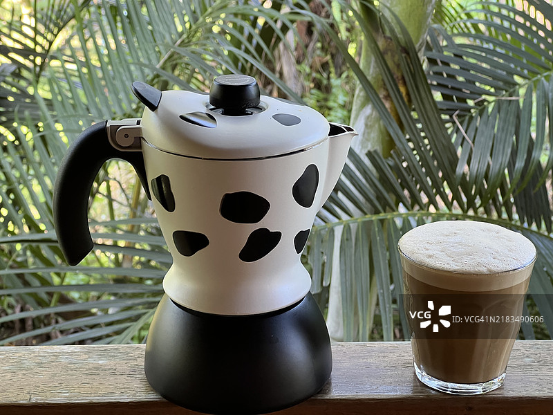 一杯热卡布奇诺咖啡与金属咖啡壶图片素材