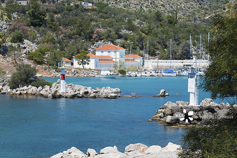 梅萨纳港口，前景是灯塔和船只，背后是岩石海岸和山脉，背景是温泉，梅萨纳半岛，阿戈利斯，萨罗尼克群岛，伯罗奔尼撒，希腊，欧洲图片素材