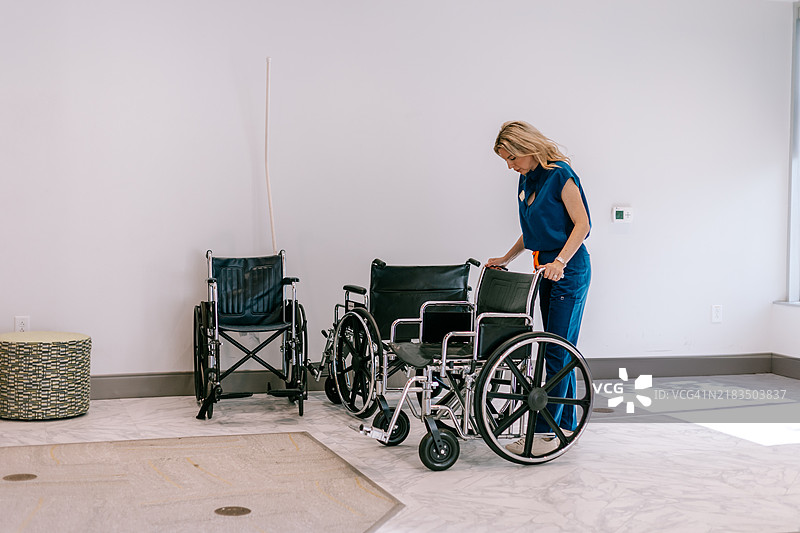 穿着医护服的工作人员在水疗中心或诊所大堂检查手动轮椅，确保一切为即将到来的病人做好准备。图片素材