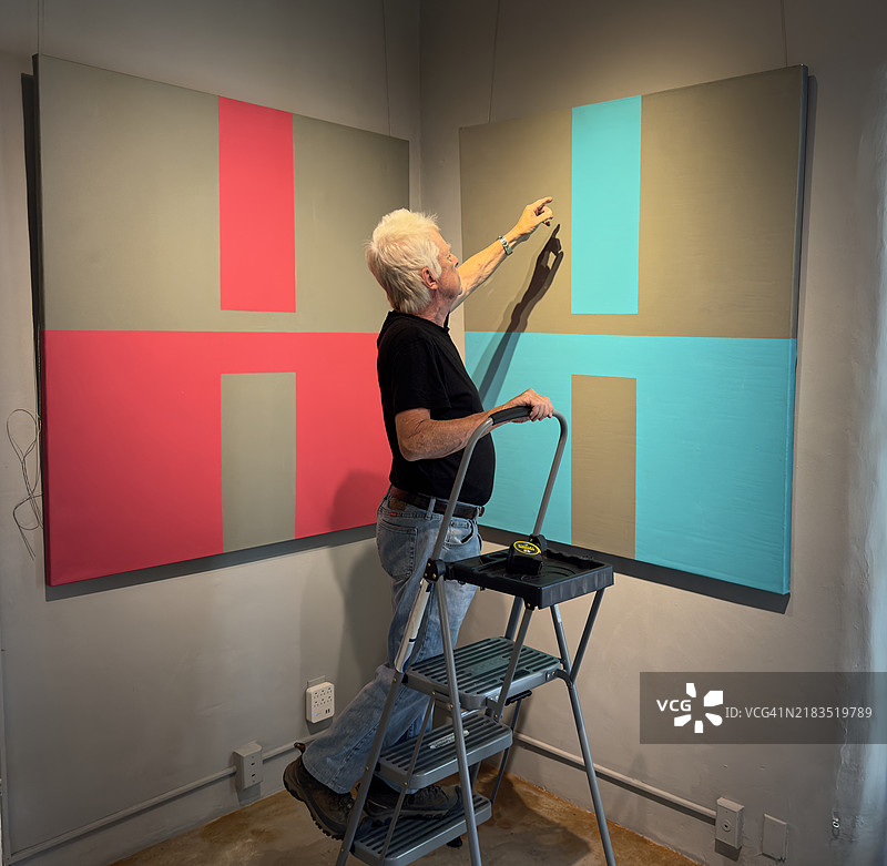 艺术家在悬挂他的作品图片素材