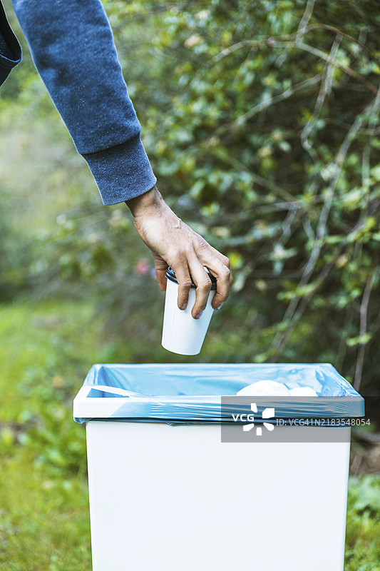 男子将垃圾桶扔出图片素材